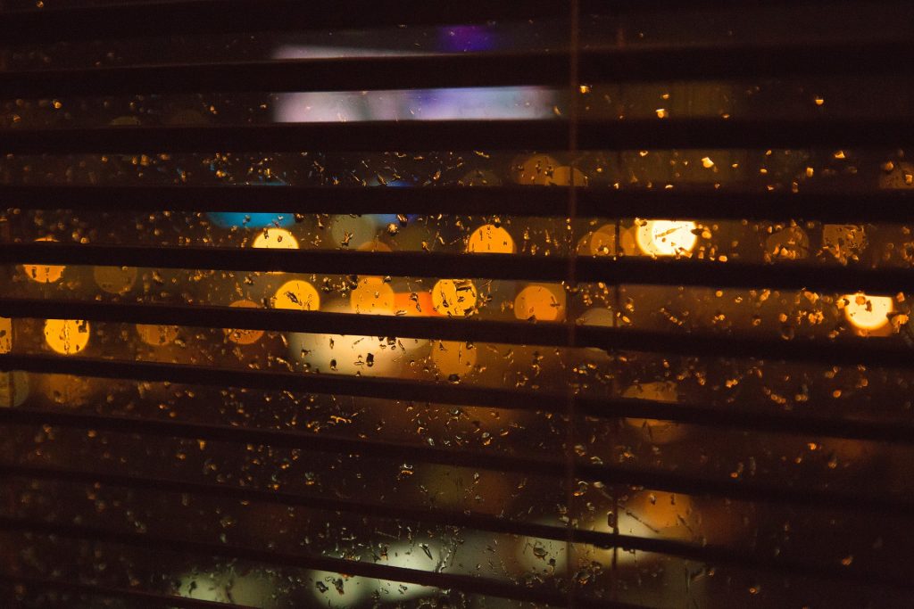 Open blinds for sleep looking out onto a rainy night
